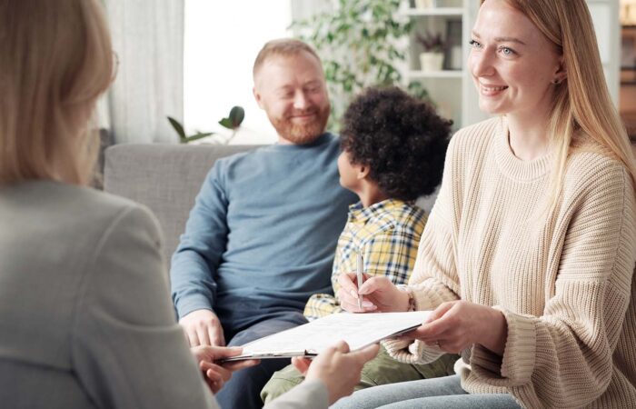 homem, criança e mãe a segurar a entregar os documentos da adoção.