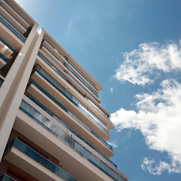 Edifício de apartamentos contra céu azul, a representar serviço de advogado de arrendamento.