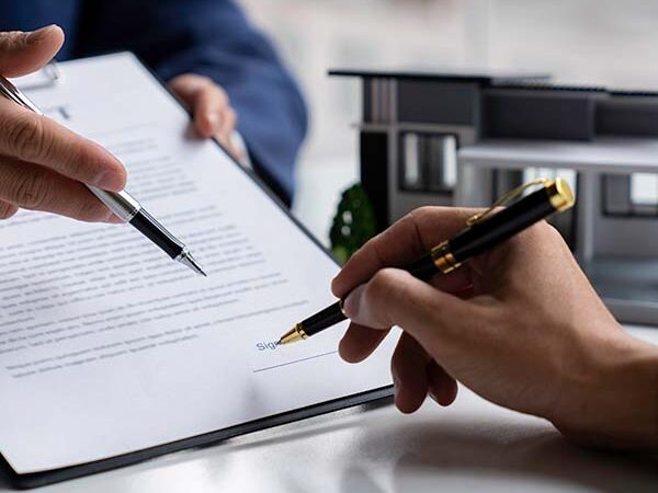 Pessoa a assinar um CPCV, representando um contrato de promessa de compra e venda.