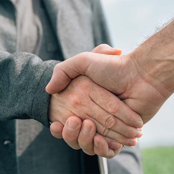 Regularização imobiliária, duas pessoas a apertar as mãos, a representar um acordo.