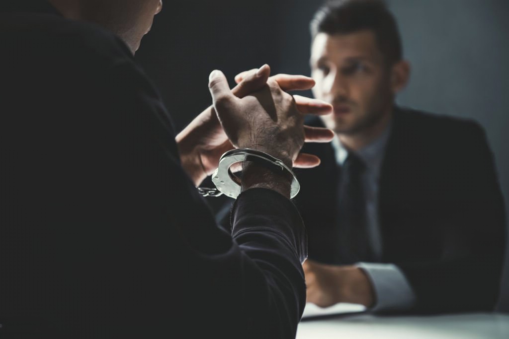 Advogado criminal a conversar com arguido preso.