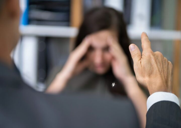 Homem apontar o dedo a mulher a simbolizar um assedio laboral