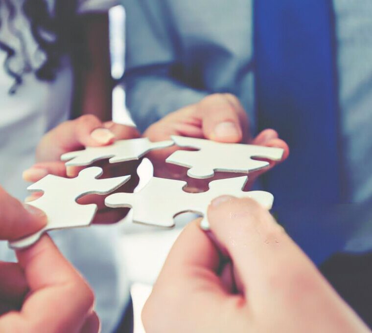 Três pessoas a com uma parte do puzzle, simulando uma cessão de quotas