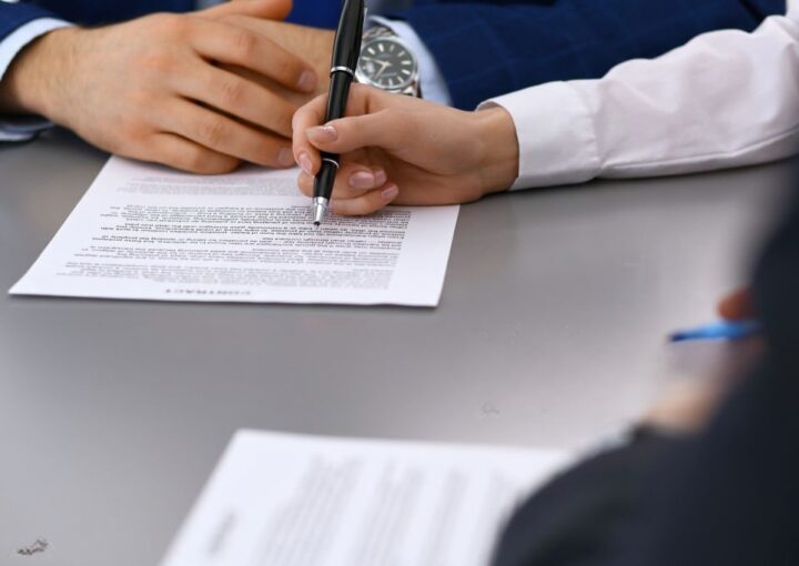 Uma pessoa assina um contrato para passar a trabalhador
