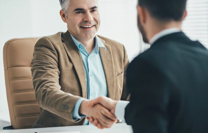 Duas pessoas a apertão a mão como forma de acordo de contrato de trabalho