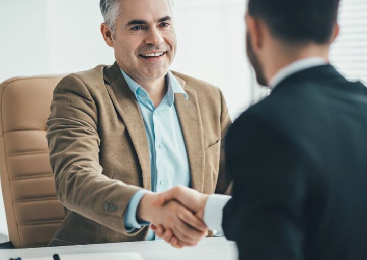 Duas pessoas a apertão a mão como forma de acordo de contrato de trabalho