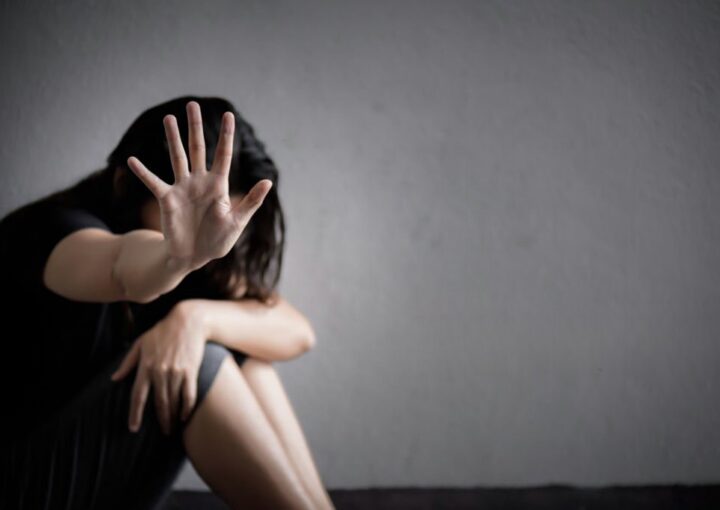 Mulher, vítima de injúria com a mão em frente à cara