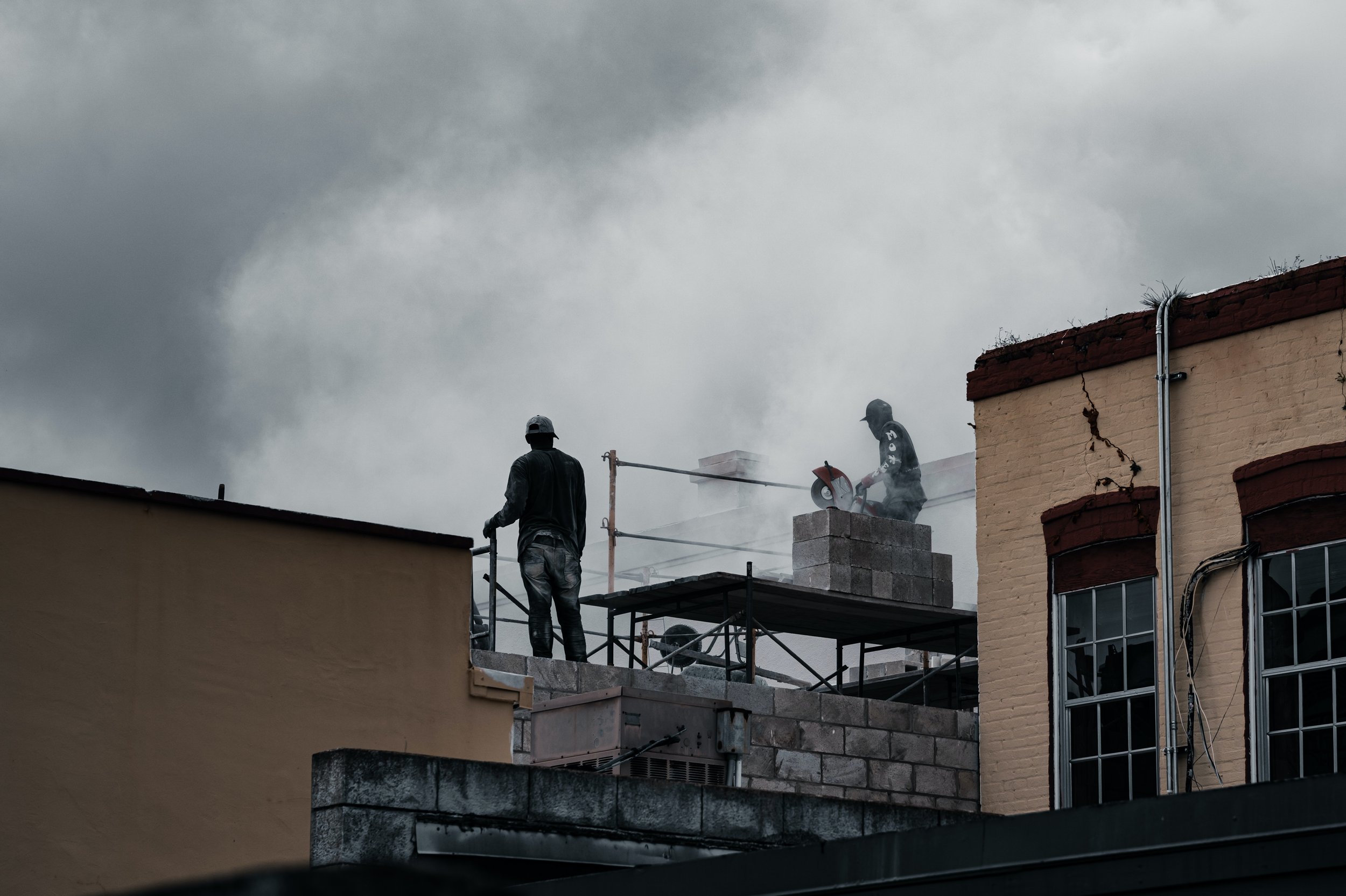 dois trabalhadores em cima de um andaime numa obra.