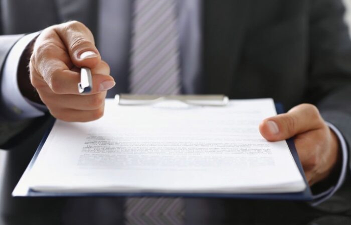 Advogado com a caneta na mão apresenta a rescisão de contrato de arrendamento.