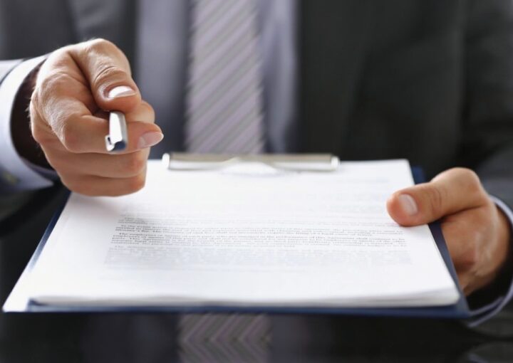 Advogado com a caneta na mão apresenta a rescisão de contrato de arrendamento.