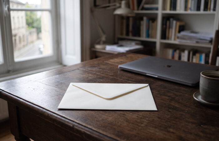 Envelope fechado pousado sobre uma secretária de escritório ao início da manhã