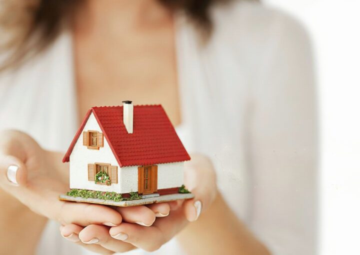 mulher a segurar a casa com as duas mão a simolizar o direito de preferência.