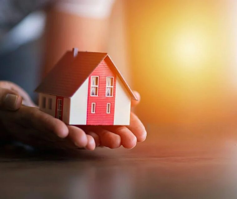 Duas mãos a segurar numa casa a simbolizar a usucapião