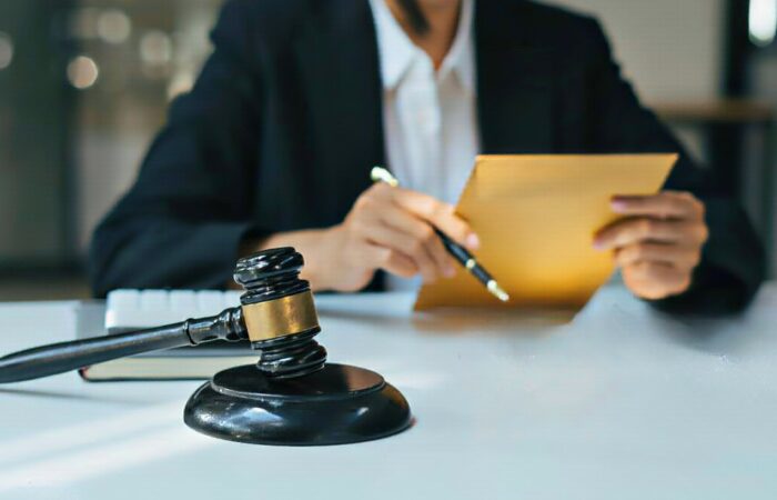 Advogado com processo fiscal em mãos com o martelo da justiça na mesa