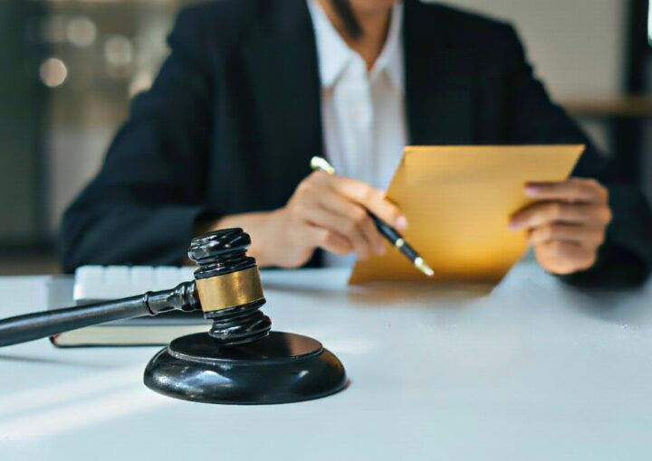Advogado com processo fiscal em mãos com o martelo da justiça na mesa