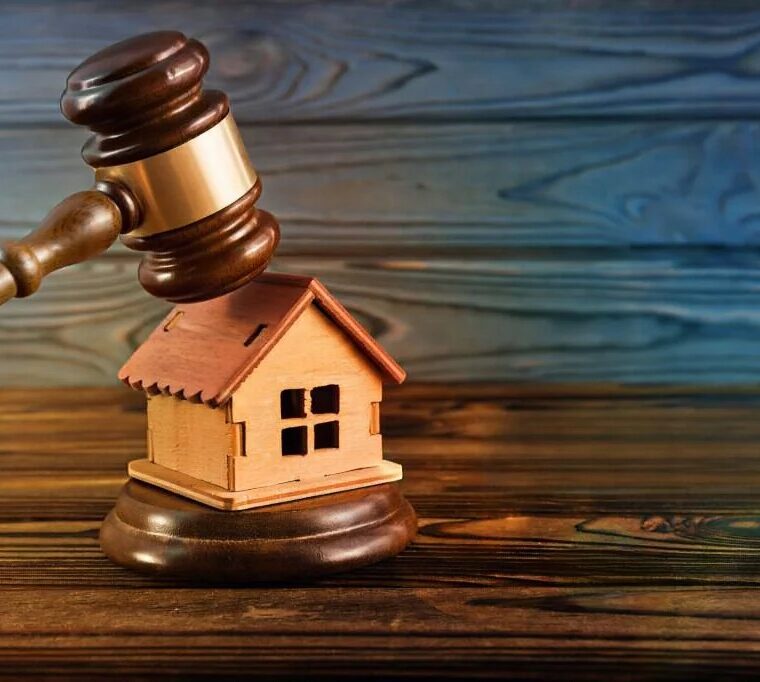 Casa e martelo da justiça a simbolizar um processo de usucapião de imóvel