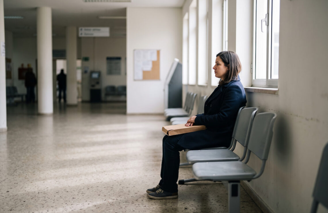 Mulher à espera numa sala de atendimento de um serviço público