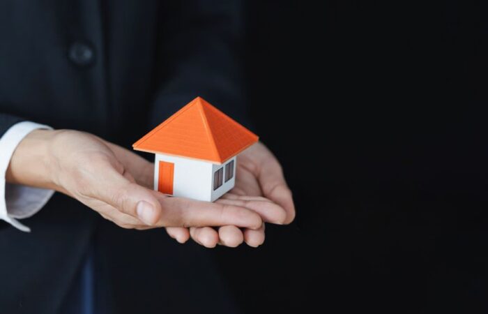 Casa miniatura em cima de uma mão a simbolizar a venda de um imóvel com usufruto.