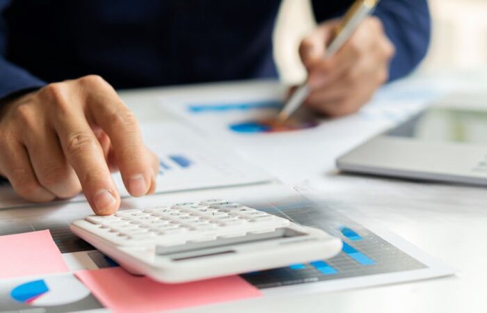 Pessoa a fazer contas com calculadora às dívidas à segurança social