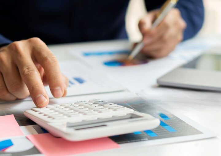 Pessoa a fazer contas com calculadora às dívidas à segurança social