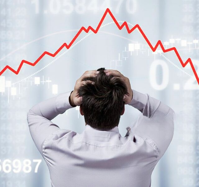 Empresário a olhar para o gráfico com as mãos na cabeça a simbolizar uma insolvência