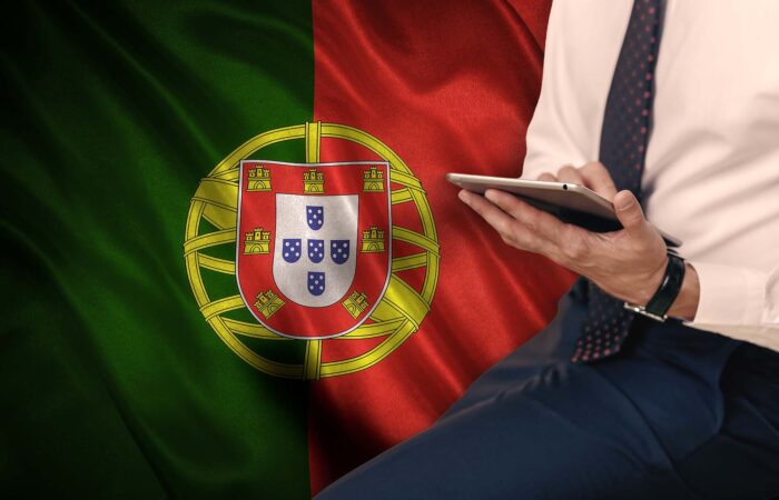 Advogado com o tablet em frente a bandeira de portugal