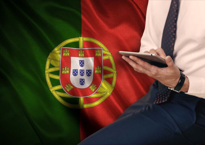 Advogado com o tablet em frente a bandeira de portugal