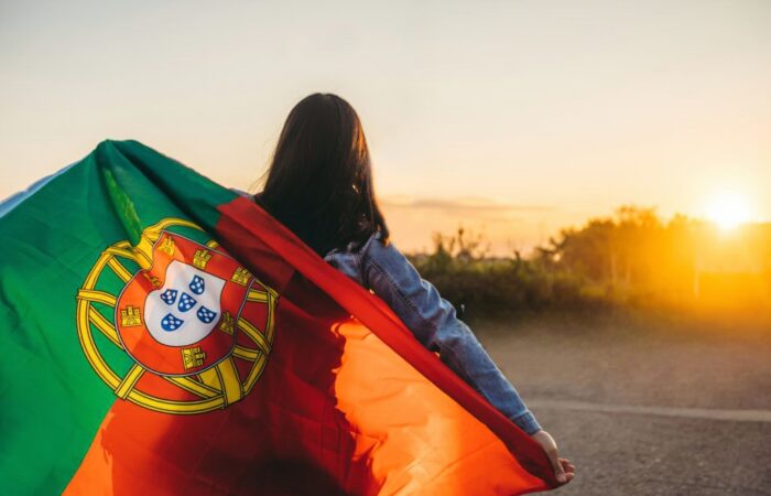 Pessoa com a bandeira de portugal a simbolizar a aquisição da nacionalidade
