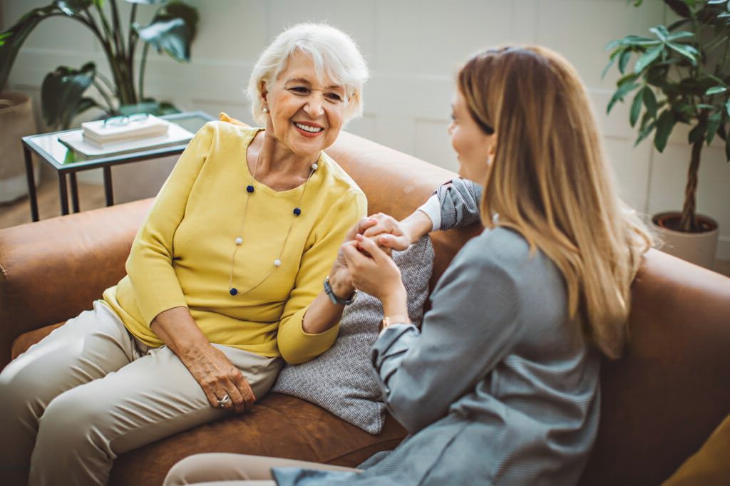 Mãe e filha sentadas no sofá a conversar sobre herança