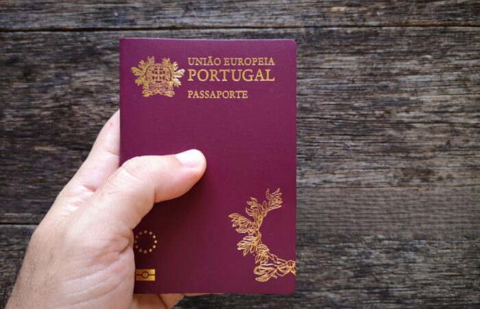 Mão a segurar o passaporte português a simbolizar a nacionalidade portuguesa