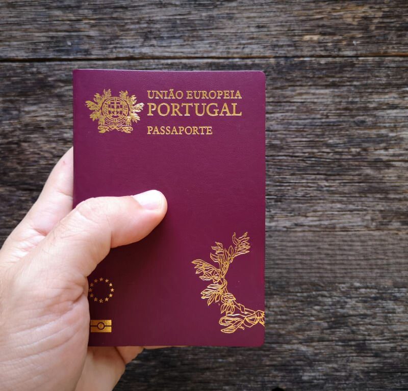Mão a segurar o passaporte português a simbolizar a nacionalidade portuguesa