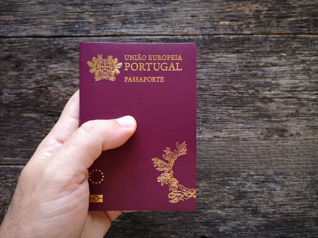 Mão a segurar o passaporte português a simbolizar a nacionalidade portuguesa
