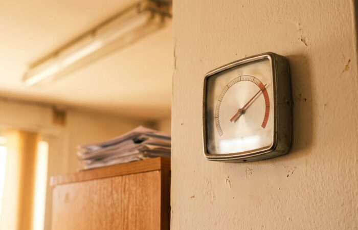 Termómetro numa parede de escritório a marcar temperatura elevada durante o horário de trabalho