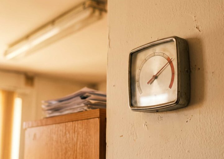 Termómetro numa parede de escritório a marcar temperatura elevada durante o horário de trabalho