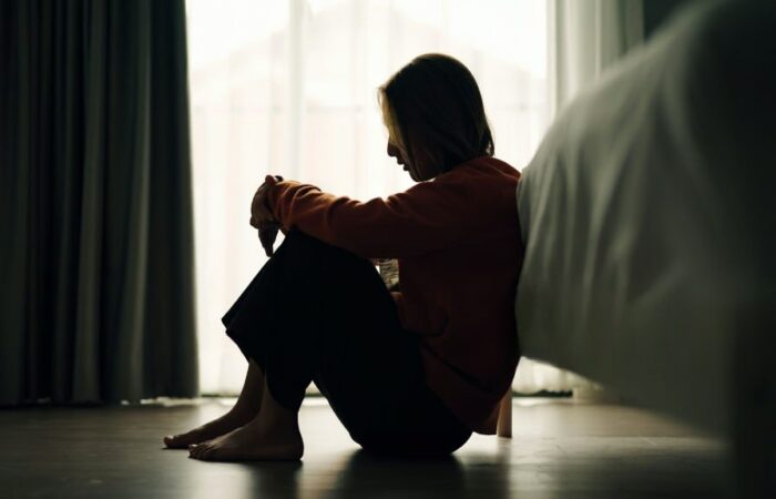 Mulher sentada no chão a pensar na separação