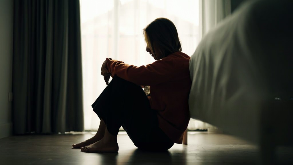 Mulher sentada no chão a pensar na separação