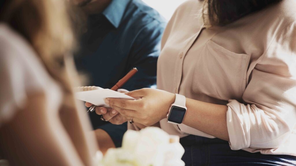 Plano aproximado de uma profissional a tirar notas num bloco durante uma reunião de consulta jurídica.