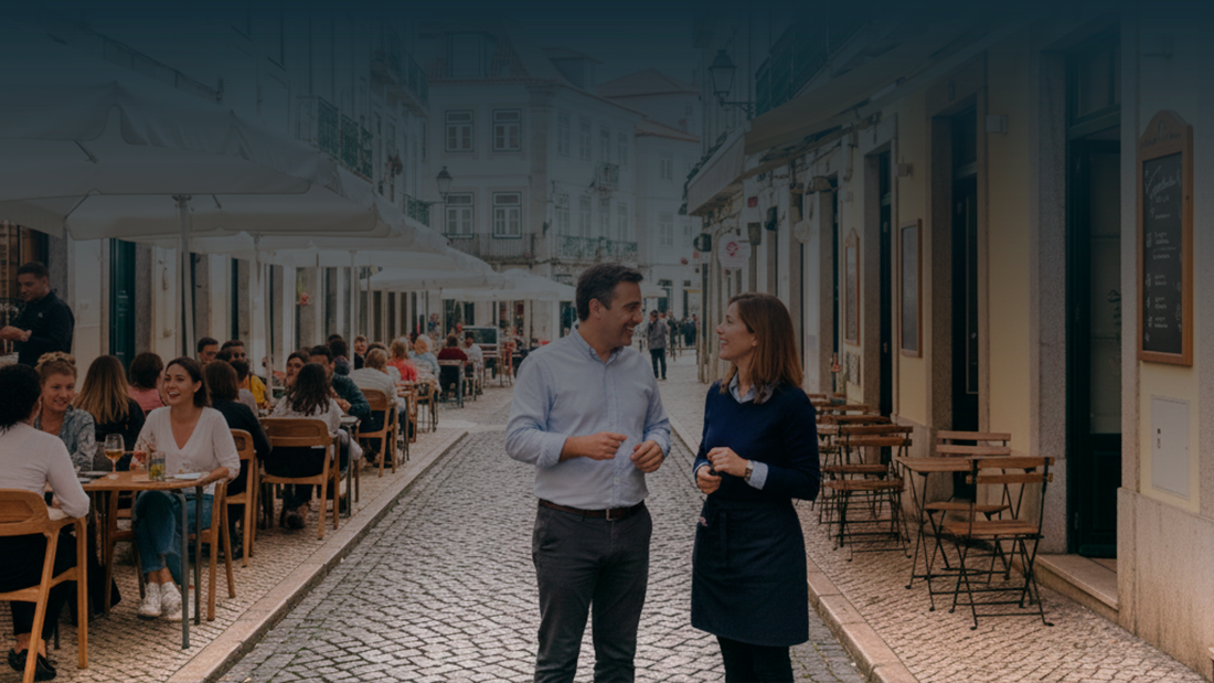 Uma rua pedonal em Portugal com duas situações distintas: à esquerda, uma esplanada completa com guarda-sóis e clientes, e à direita, mesas simples junto à fachada, representando a diferença entre licenciamento obrigatório e dispensado.