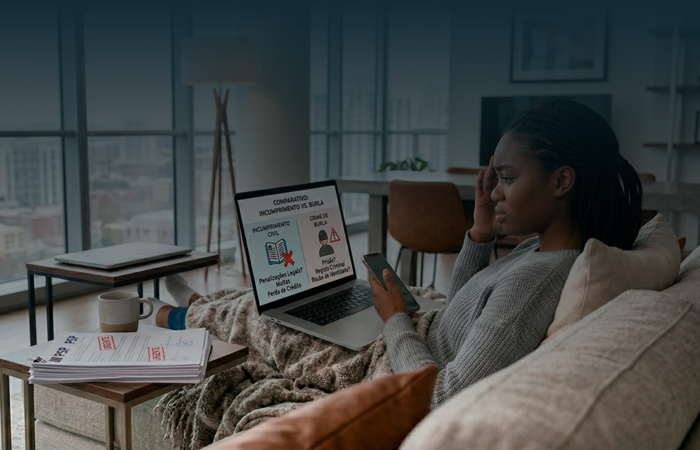 Mulher preocupada no sofá a usar portátil para comparar as diferenças entre incumprimento civil e crime de burla, com documentos da PSP ao lado.