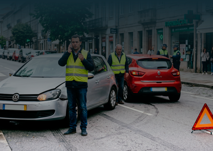 Condutores com coletes refletores após acidente de viação a sinalizar a estrada e a pedir assistência.