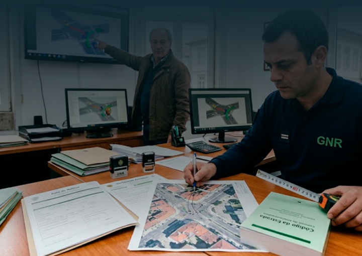 Agente da GNR e especialista a analisar fotografias de danos, mapas e auto de notícia para determinar a responsabilidade no acidente.