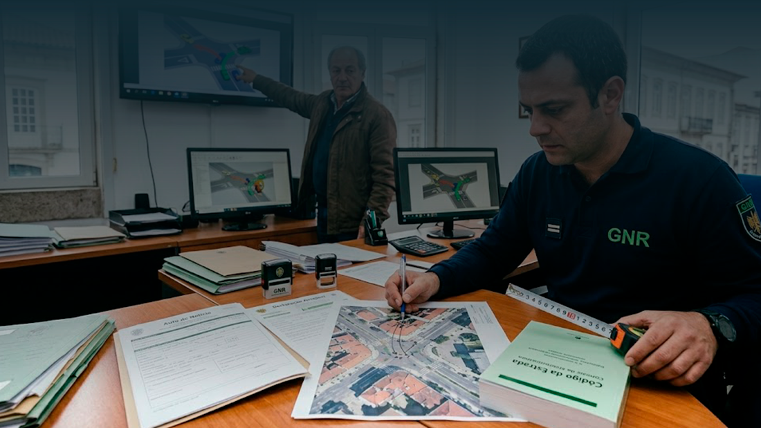 Agente da GNR e especialista a analisar fotografias de danos, mapas e auto de notícia para determinar a responsabilidade no acidente.