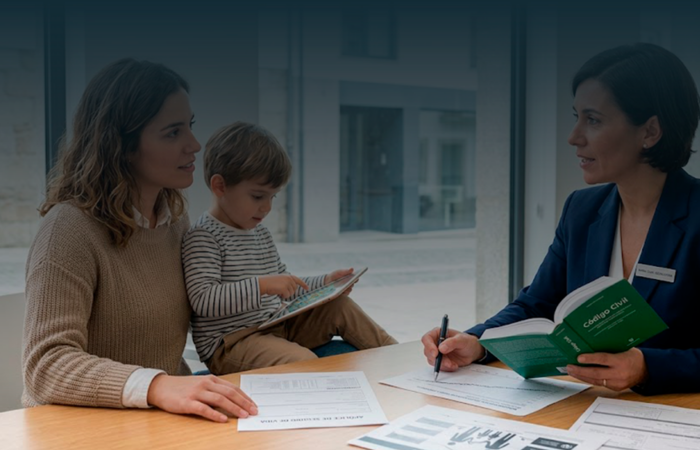 Mãe jovem com filho pequeno em reunião com consultora de seguros para analisar coberturas de seguro de vida.