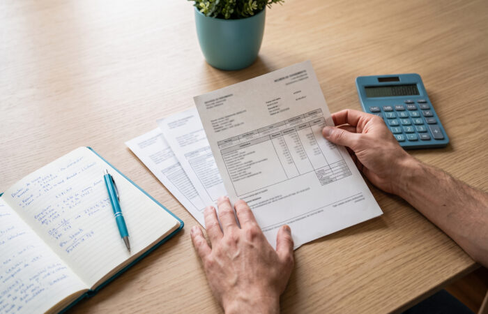 Recibos de vencimento e carta de cessação de contrato sobre uma mesa, ao lado de uma calculadora