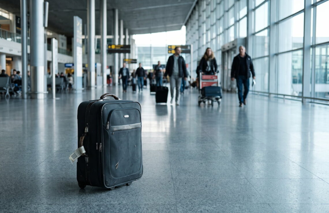 Mala de viagem sozinha no chão de um átrio de chegadas de aeroporto